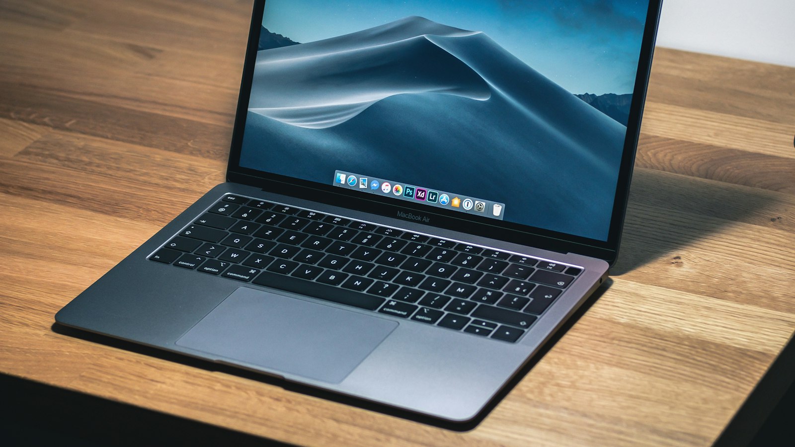MacBook Air ouvert sur un bureau en bois