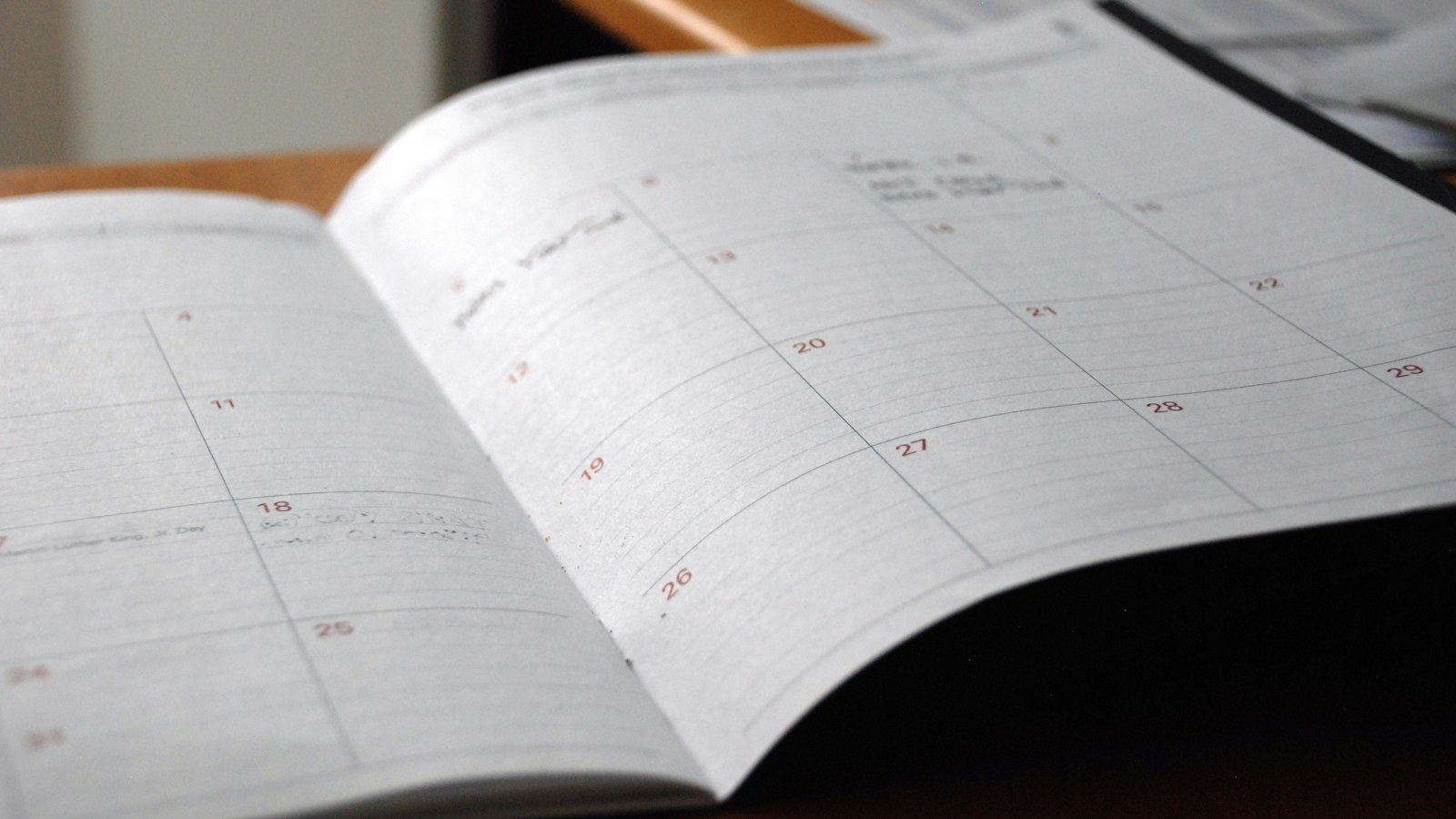 Agenda mensuel ouvert sur un bureau en bois
